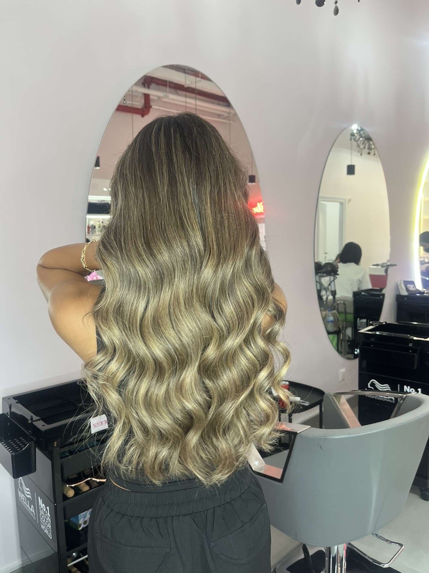 Long, glossy blonde balayage waves finished at The Perfect Blend